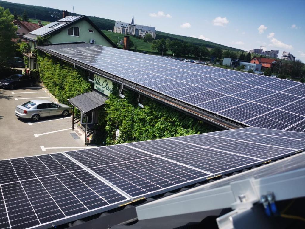 un groupe de panneaux solaires sur le toit d'un bâtiment dans l'établissement Vila Chesa, à Corunca