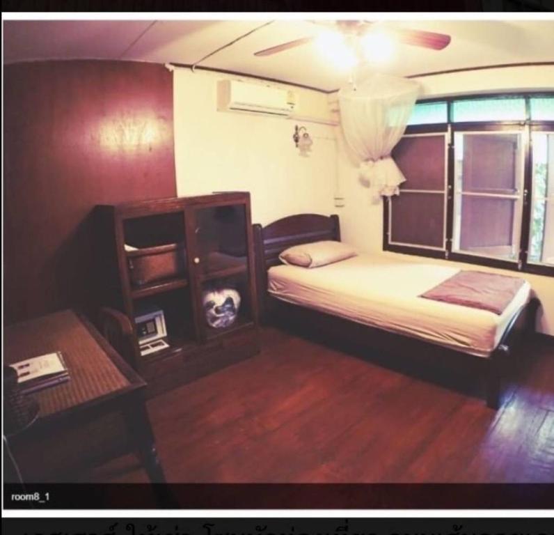 a bedroom with a bed and a table and a bed sidx sidx sidx at Tata GuestHouse in Chiang Mai