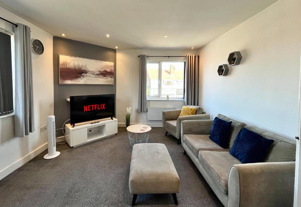 a living room with a couch and a tv at Lovely Serviced Apartment - Near Doncaster Hospital in Doncaster
