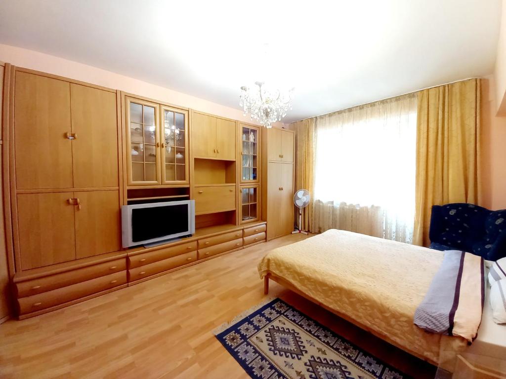 a bedroom with a bed and a flat screen tv at "Золотой Квадрат" Центр Квартира - "Golden Square" Apart in Almaty