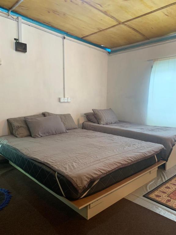 1 dormitorio con 2 camas en una habitación en SABAYA HOMESTAY, en Balik Pulau