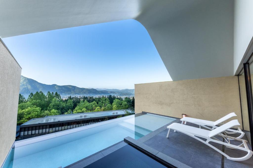 una silla blanca sentada en el borde de una piscina en ENOWA, en Yufu
