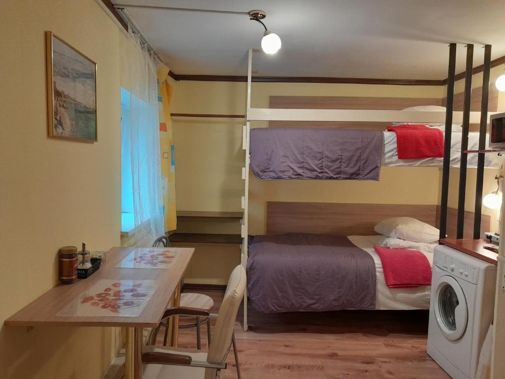 Jest to pokój wieloosobowy z łóżkiem, stołem i biurkiem. w obiekcie Avotu Stabu Private Flats in a Separate House For One or Couple w Rydze