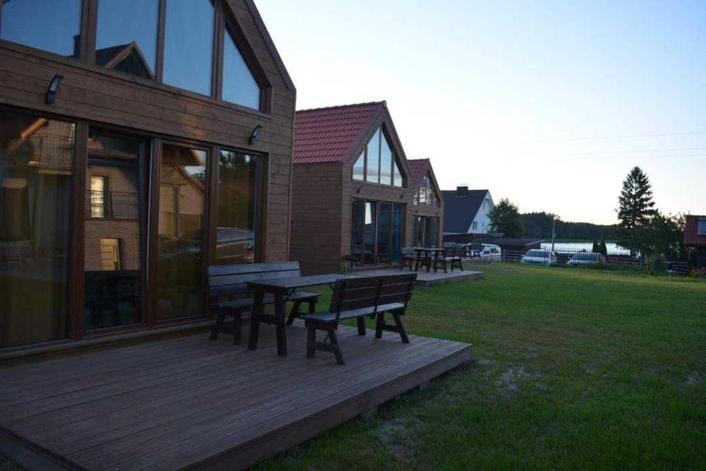 a wooden deck with a bench next to a house at Apartamenty Drewniaki in Rydzewo