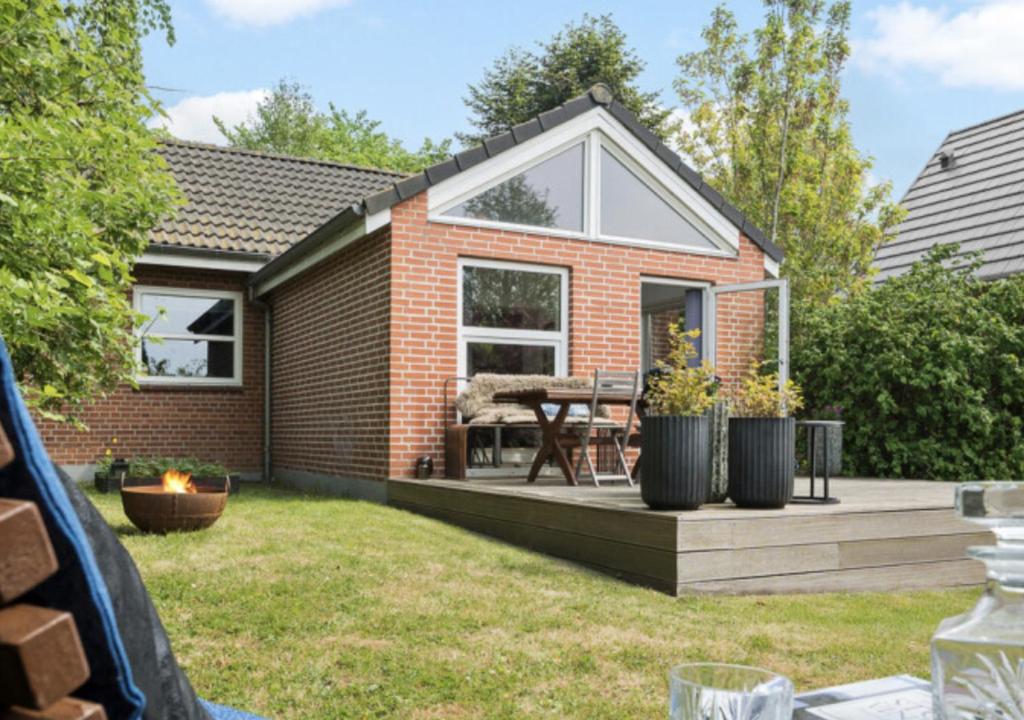 a brick house with a deck with a table at Aarhus - cozy house, 10 min from city center in Aarhus