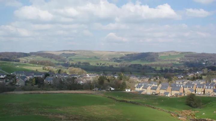 um campo verde com casas e uma cidade à distância em Bridge Farm Caravan em Buxton