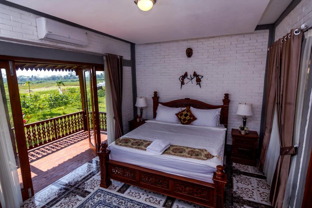 Balkondes Majaksingi Jasamarga في بوروبودور: غرفة نوم بسرير وشرفة