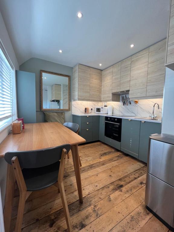 uma cozinha com uma mesa de madeira e um lavatório em Red Brick House em Yeovil