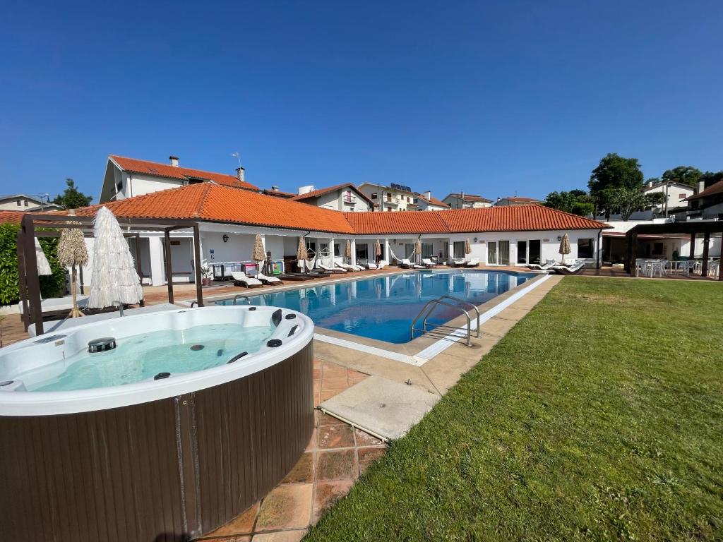 a swimming pool in a yard next to a house at A Casa Branca in Santa Comba Dão