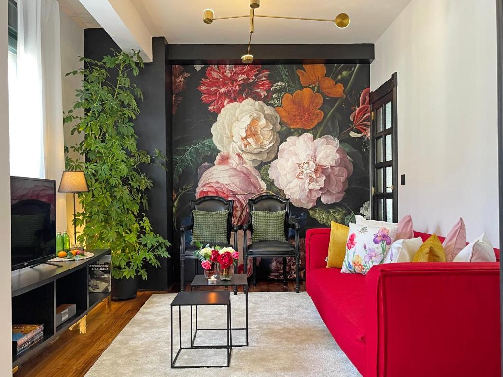 a living room with a red couch in front of a painting at Cambados Classic Chic A in Cambados