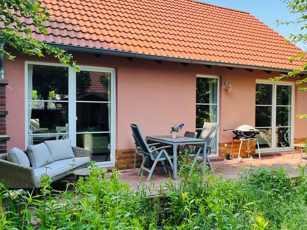 een patio met een tafel en stoelen voor een huis bij Brenner‘s Waldhaus in Hergersweiler