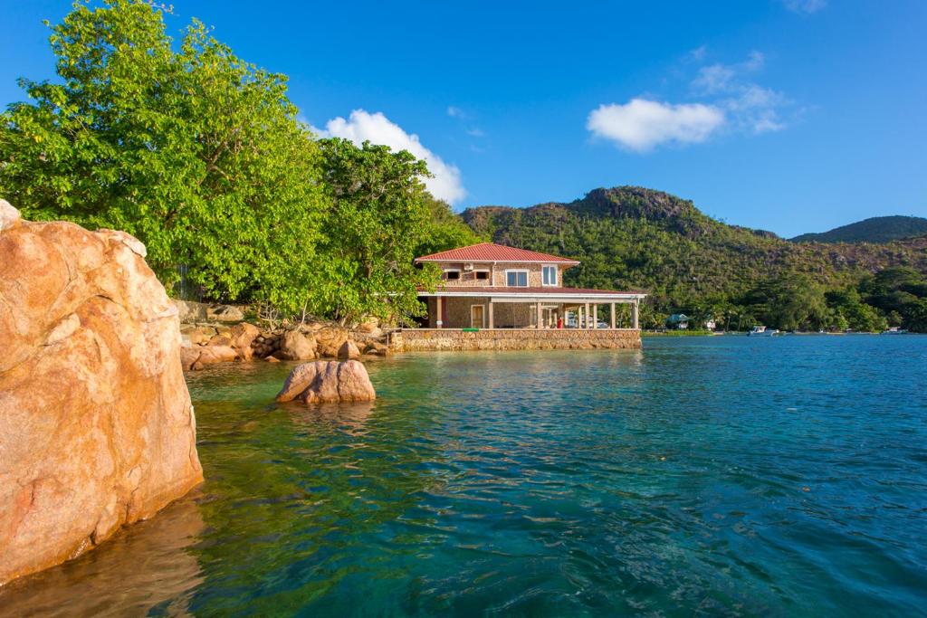 a house in the middle of a body of water at La Saline in Anse Possession