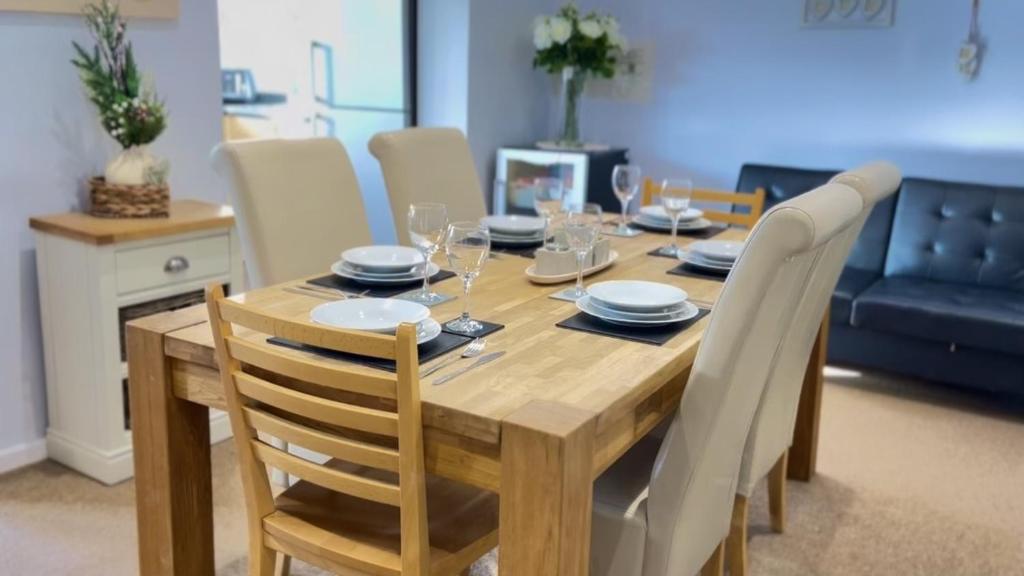 uma mesa de madeira com cadeiras e uma sala de jantar em Modern 3 bed house 2 parking spaces contractors welcome em Stevenage