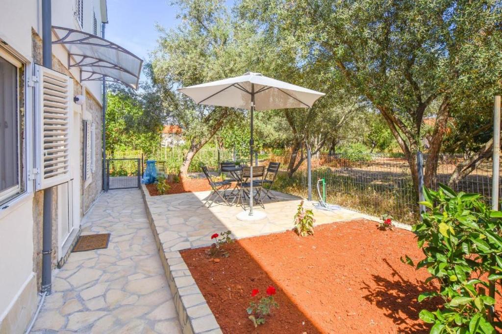 a patio with a table and an umbrella at Suite Apartment Toni in Poljana