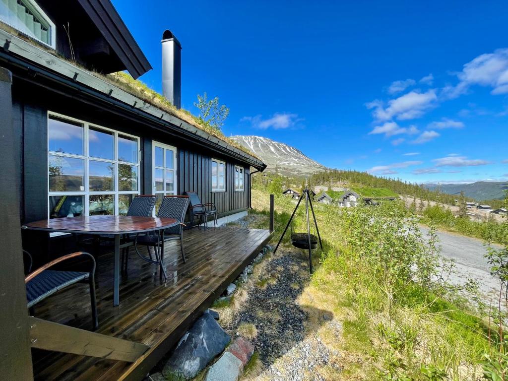 una casa con tavolo e sedie su una terrazza di Gausta Lodge med 6 sengeplasser i nærhet til Gaustatoppen a Gaustablikk