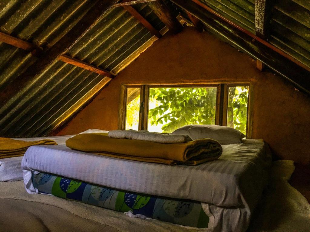 2 camas en una habitación con ventana en SHADOW MASK BUNGALOW en Pattipola