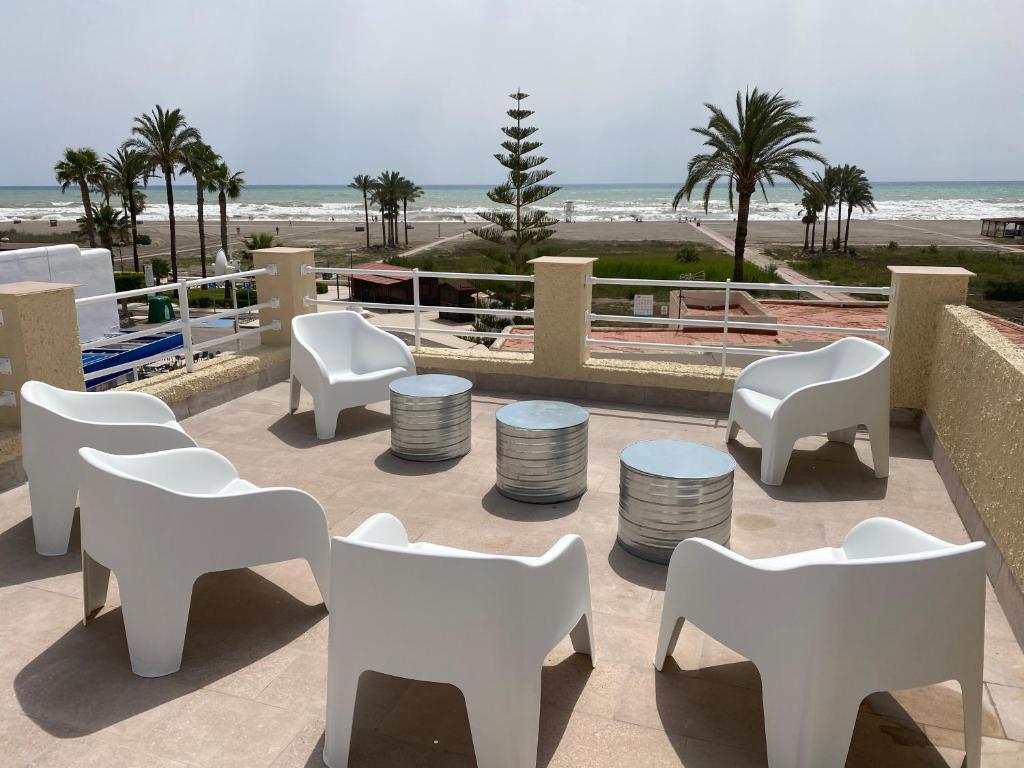 d'une terrasse avec des chaises et des tables blanches et la plage. dans l'établissement Las Marinas, à Vera