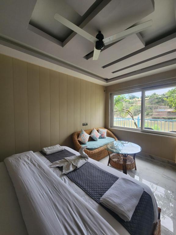 Un dormitorio con una cama y un sofá y una ventana. en Karwaan by the Ganges, en Rishīkesh