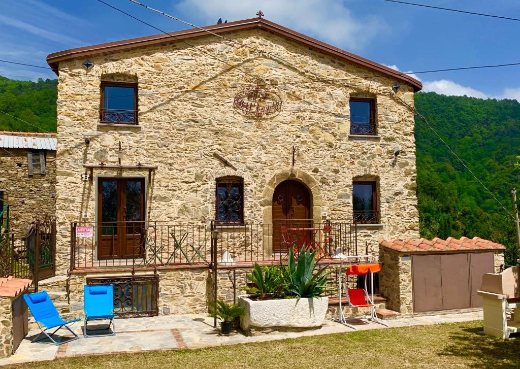 a stone house with chairs in front of it at Casa Dell’Angelo Serafino in Castelnuovo Magra