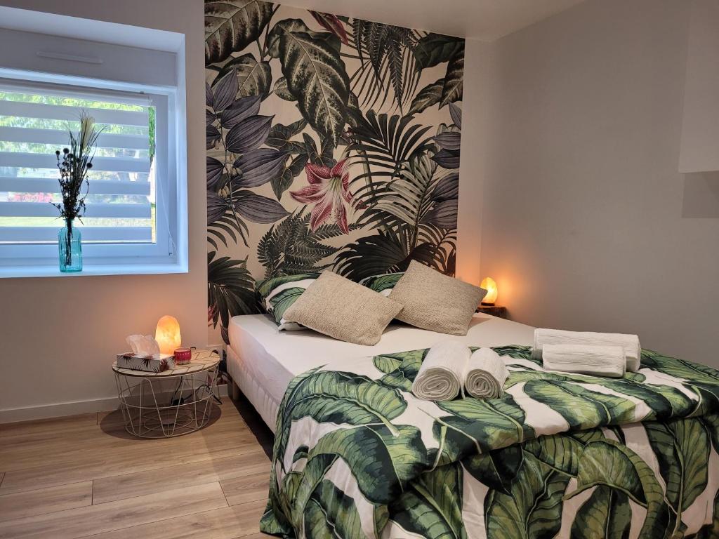 1 dormitorio con 1 cama con papel pintado tropical en La Passerelle en Mernel