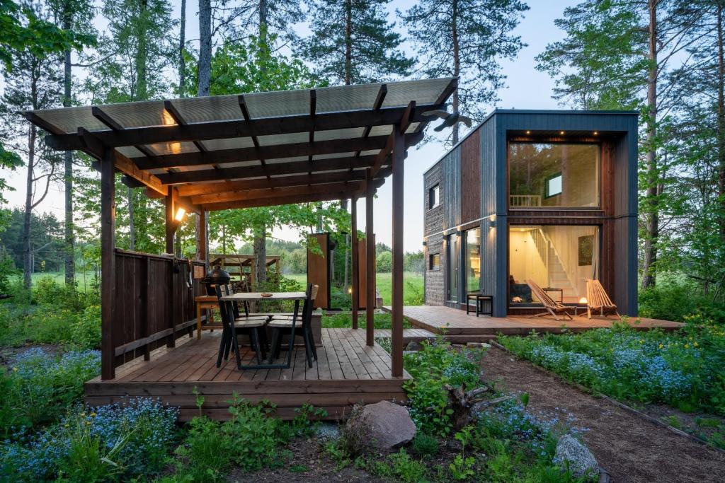 a tiny house with a deck in the woods at SHANTI FOREST HOUSE Guest house with mirror sauna 