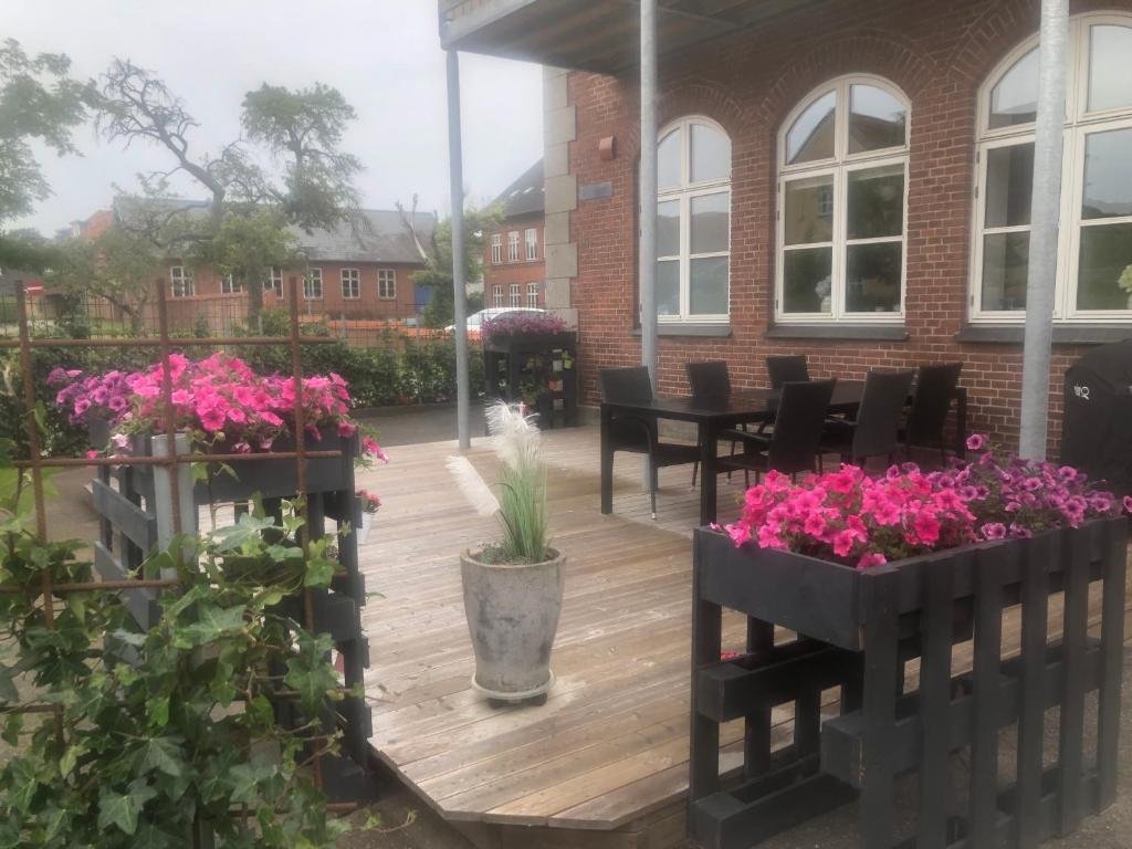 un patio con un mazzo di fiori e piante di Den lille Skole - Ferie på Ærø i Marstal by a Marstal