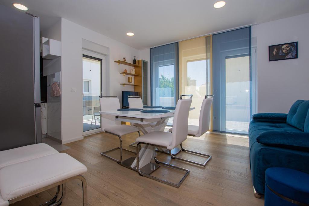 salon ze stołem i krzesłami oraz niebieską kanapą w obiekcie Apartman Goldy w mieście Zadar