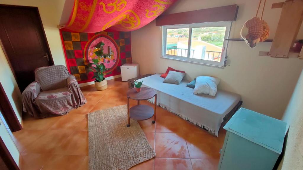 a small room with a bed and a window at Natural Mystic Hostel in Costa da Caparica