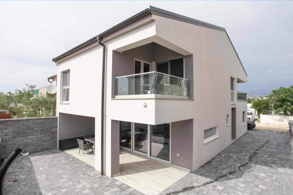 a large white house with a balcony at Ni-Ka in Pag