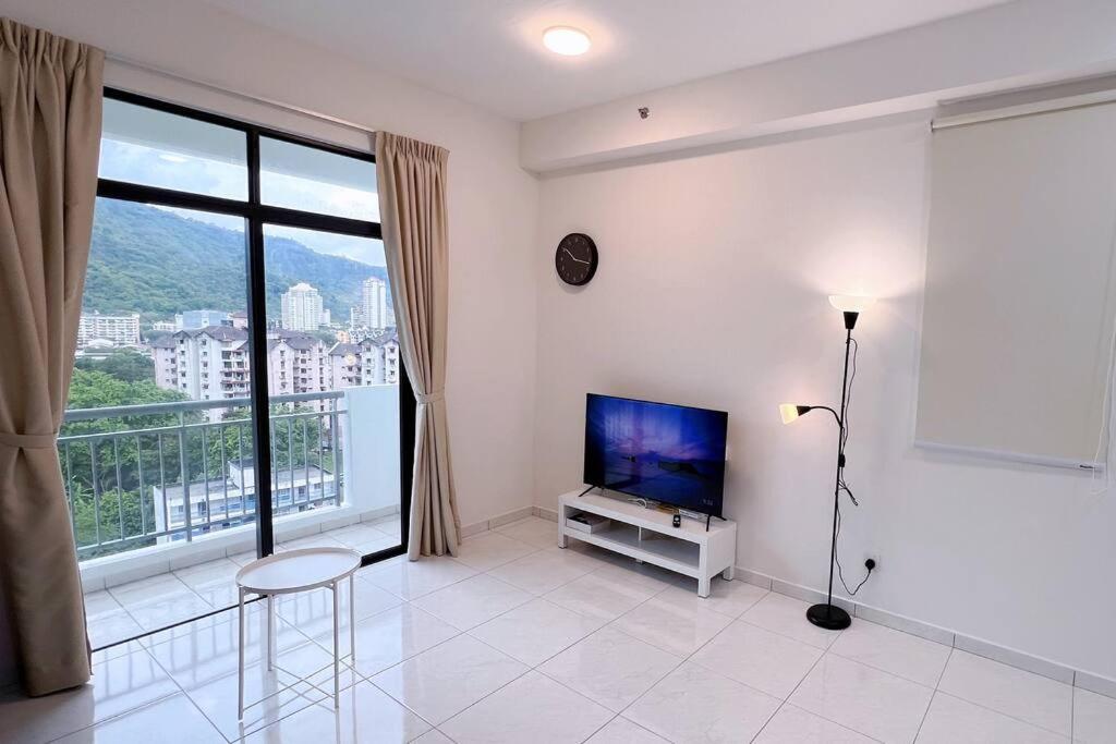 a living room with a tv and a large window at TheSun #Studio #BayanLepas #Pisa in Kampong Manggis