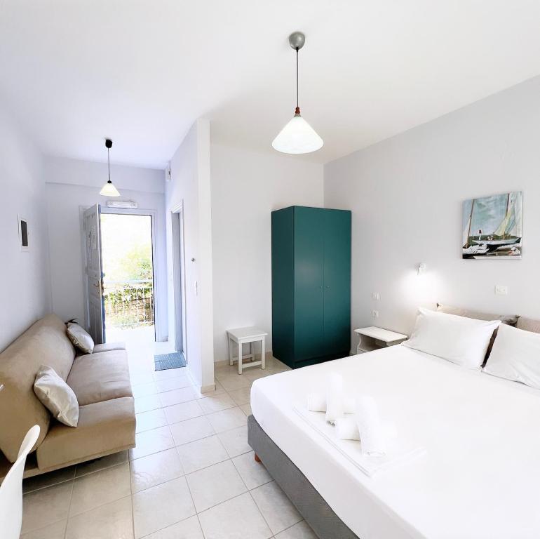 フィニクーダにあるIlias Apartmentsのベッドルーム(大きな白いベッド1台、ソファ付)