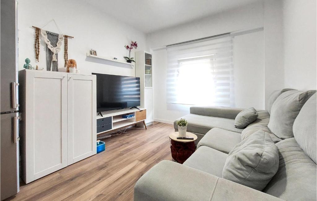 a living room with a couch and a flat screen tv at Nice Apartment In Castell De La Plana With Wifi And 3 Bedrooms in Castellón de la Plana