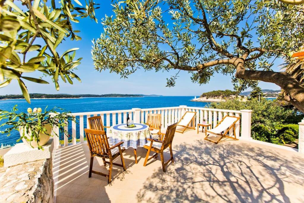 a table and chairs on a balcony overlooking the ocean at Villa Porthos in Hvar