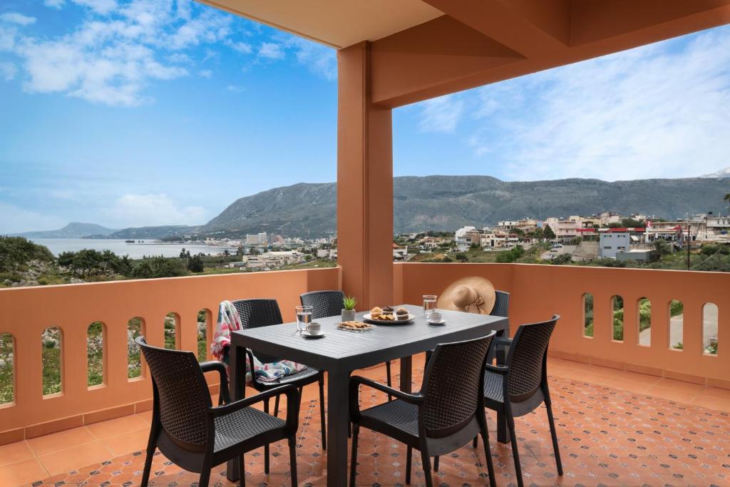 a table and chairs on a balcony with a view at Villa Androniki in Souda