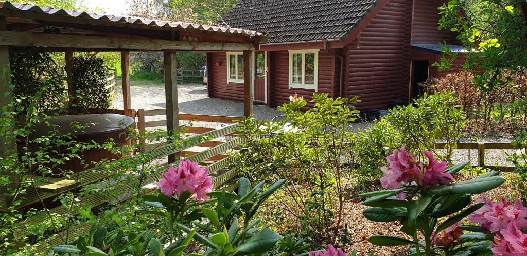 a garden with pink flowers in front of a house at Springburncabins in Elgin