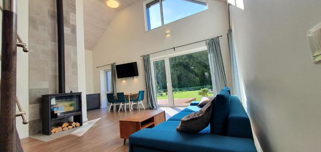 uma sala de estar com um sofá azul e uma televisão em Kambarių nuoma Naujojoje Akmenėje em Naujoji Akmenė