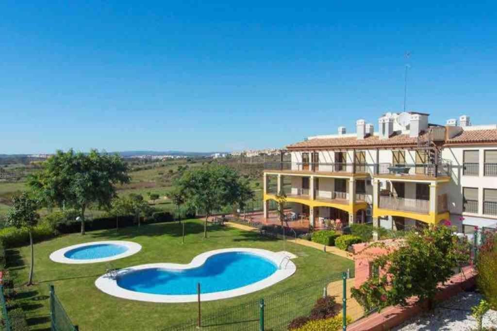 une maison avec 2 piscines dans la cour dans l'établissement Apartamento MG, à Huelva