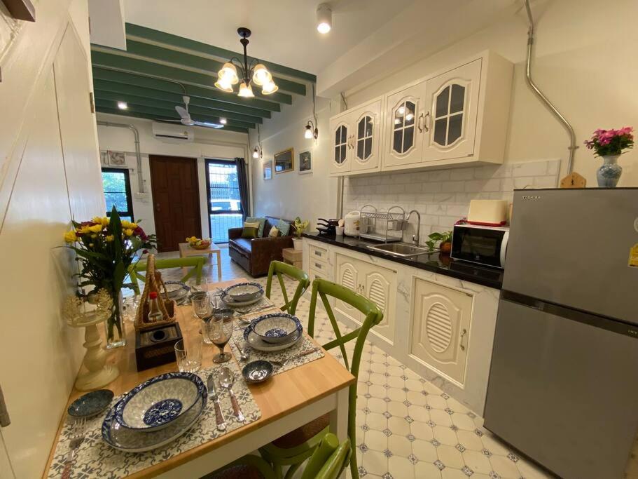 eine Küche mit einem Tisch und einem Kühlschrank in der Unterkunft 1 min walk to BTS, 3 Bed 3 Bath, Entire House in Bangkok