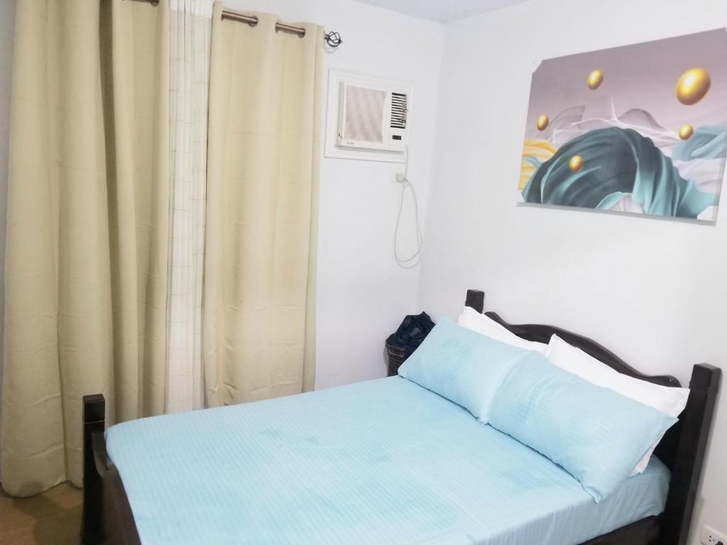 a bedroom with a blue bed and a curtain at Family Groups Staycation in Tagaytay in Tagaytay