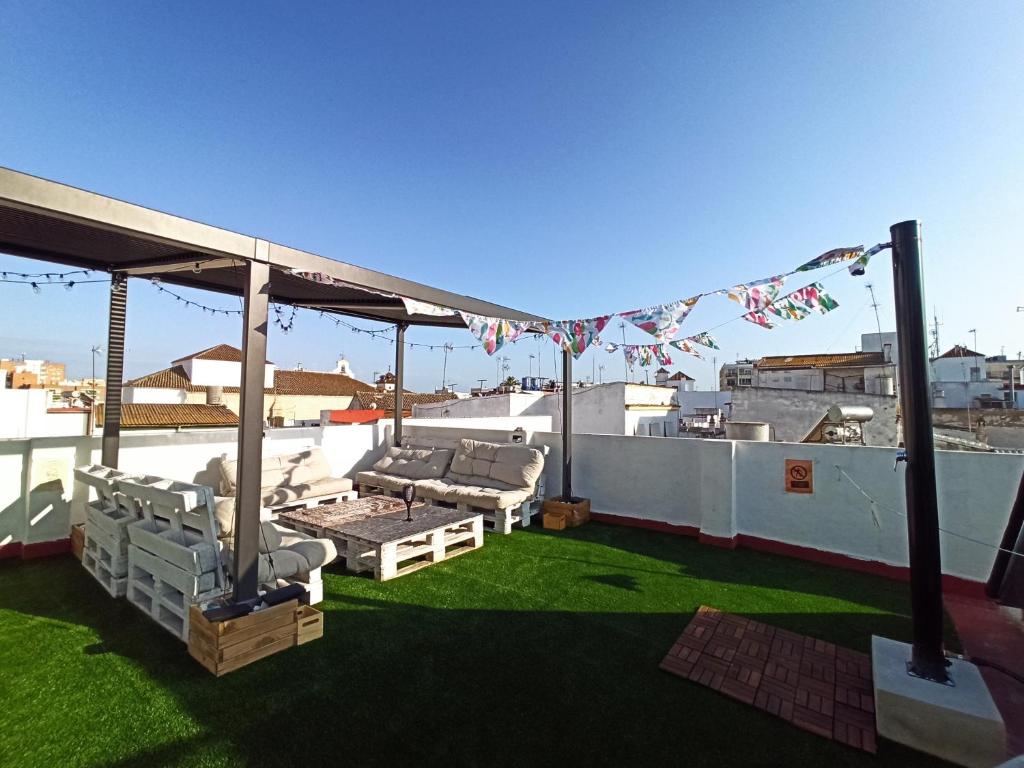 un patio all'ultimo piano con divani e sedie sul tetto di Vivian's Guest House a Jerez de la Frontera