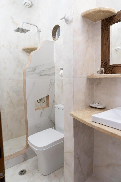 a white bathroom with a toilet and a sink at Alexandros by the Beach - Serifos in Livadakia