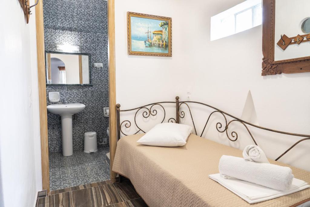 a bedroom with a bed and a sink and a mirror at Alexandros by the Beach - Serifos in Livadakia