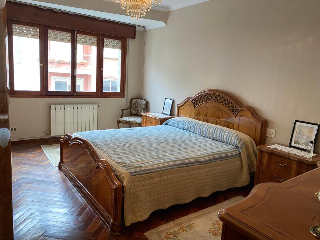 Un dormitorio con una gran cama de madera y una ventana en Apartamento de 4 habitaciones en Cabo de Cruz, en Boiro