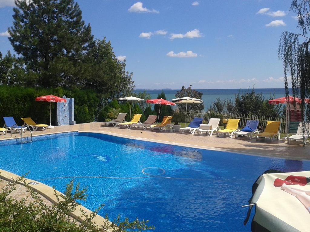 una gran piscina con sillas y sombrillas en Rai Hotel, en Kavarna