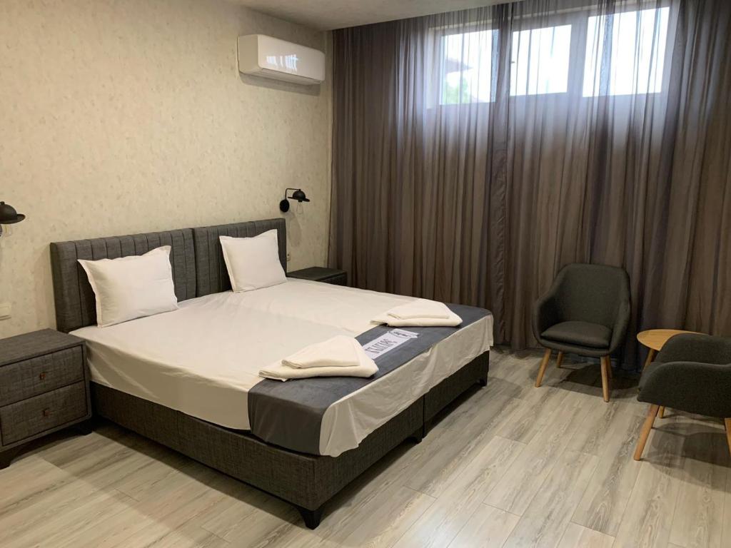 ein Schlafzimmer mit einem Bett, einem Stuhl und einem Fenster in der Unterkunft Стандартна стая Пламен in Vratsa