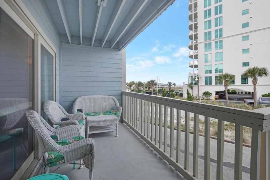 a balcony with chairs and a view of a building at Summer House West B103 in Gulf Shores