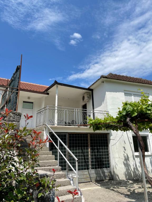 een wit huis met een trap ervoor bij Honey Home in Podgorica