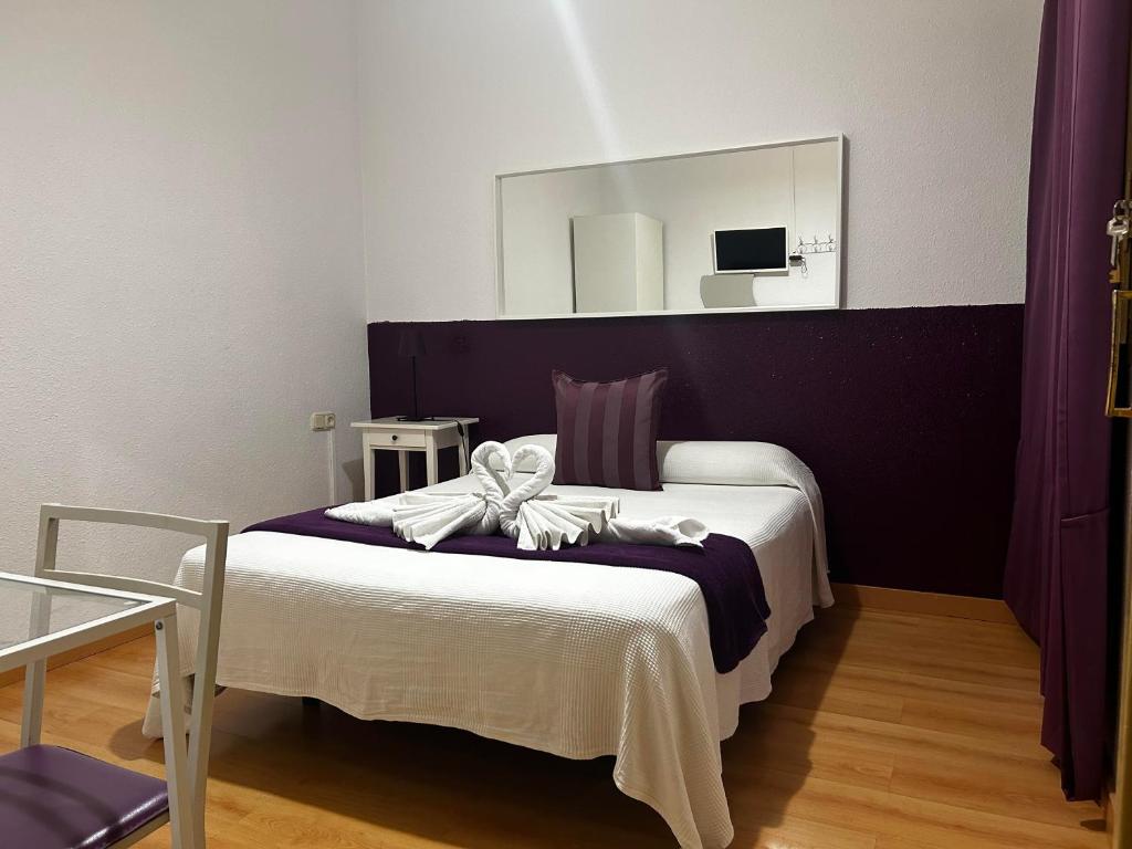 1 dormitorio con 1 cama con espejo grande en Hostal Muntaner, en Barcelona