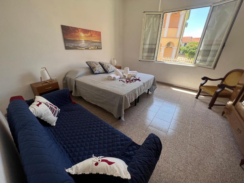un soggiorno con un divano blu e un letto di Porto Alabe casa levante a Porto Alabe