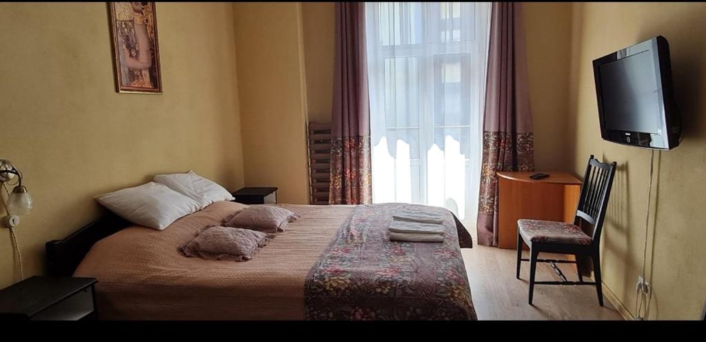 - une chambre avec un lit, une télévision et une fenêtre dans l'établissement Camino Cesis, à Cēsis
